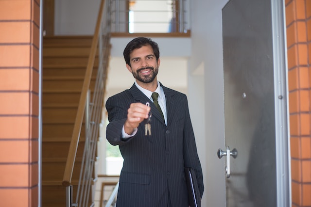 a property manager standing in a door holding out house keys